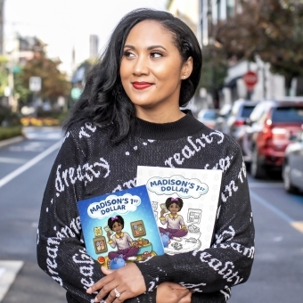 Black female entrepenuer standing with books in her hand 