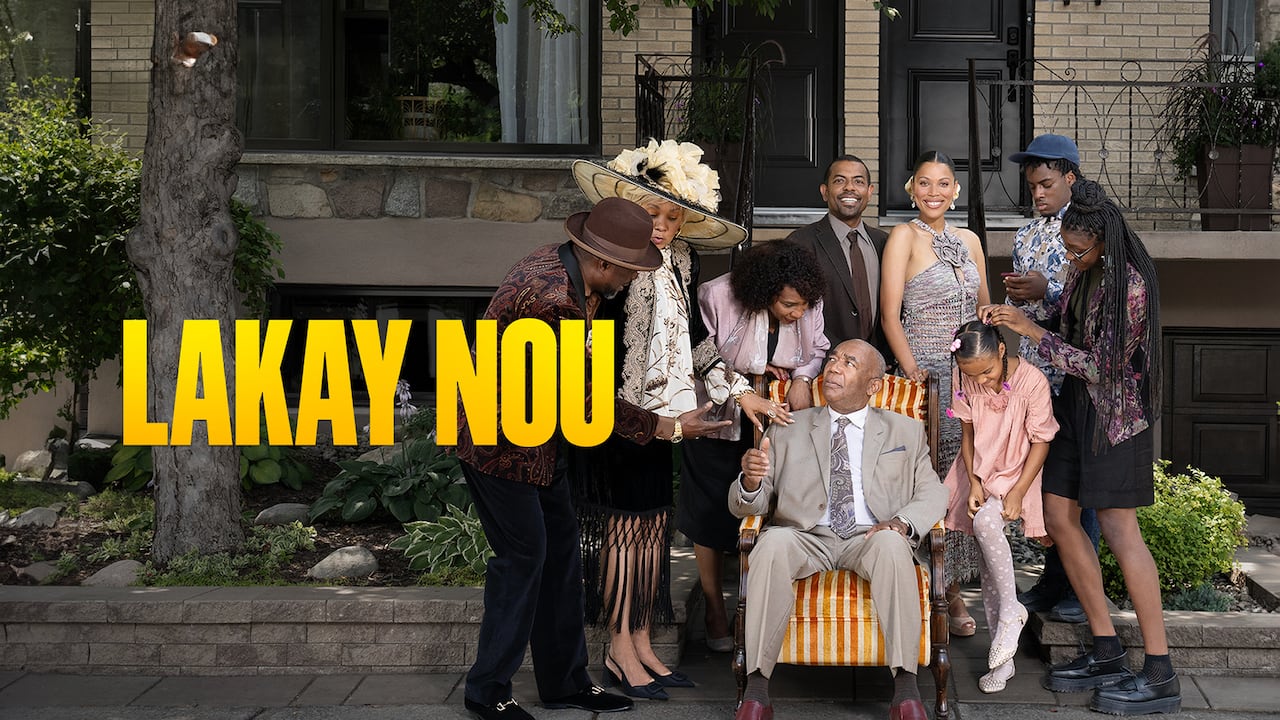 A Black man sitting in an armchair in front of a home with people of varying ages surrounding him. They are all in fancy attire (suits, dresses). On the left are the words: Lakay Nou in yellow over the photo. It's a show poster for the series Lakay Nou.